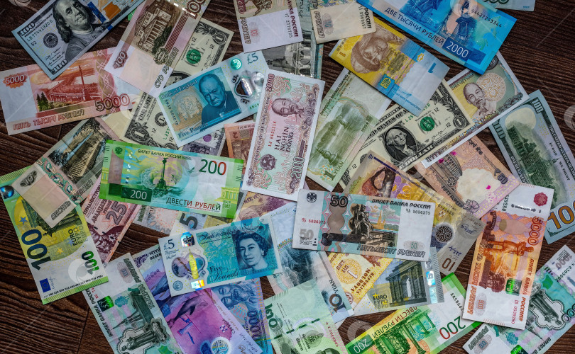 Скачать Россия,Сибирь 09 июня 2022 год. разноцветные банкноты разных стран на деревянной поверхности. фотосток Ozero