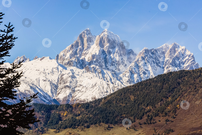 Скачать Горный хребет Ушба покрыт снегом, а небо ясное. фотосток Ozero