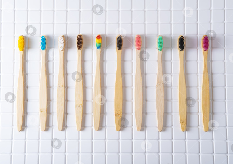 Скачать Бамбуковые зубные щетки с разноцветной щетиной на плитке в ванной комнате фотосток Ozero