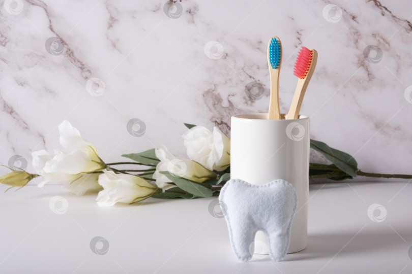Скачать Бамбуковые зубные щетки с розовой и голубой щетиной в белом стакане фотосток Ozero