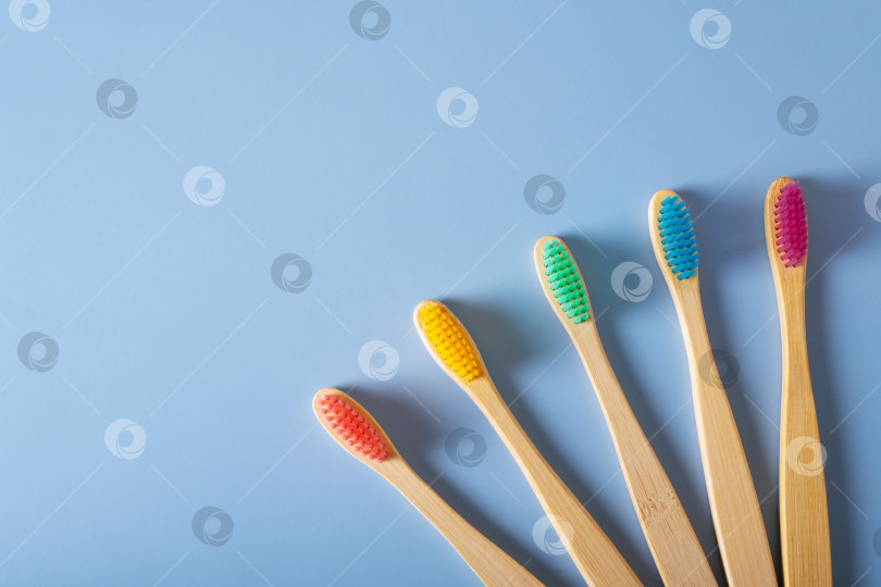 Скачать Пять бамбуковых зубных щеток с разноцветной щетиной на синем фоне фотосток Ozero