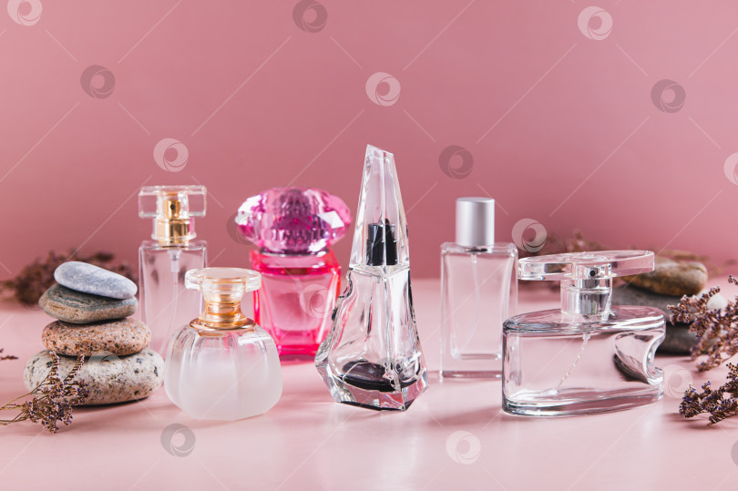 Скачать Красивая композиция из флакончиков духов в розовых тонах на столе фотосток Ozero