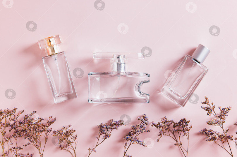 Скачать Крупный план расположения флаконов духов в розовых тонах на столе вид сверху фотосток Ozero
