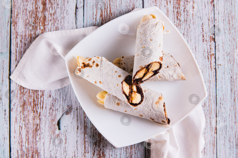 Скачать Крупный план сладких булочек с шоколадом и бананом на тарелке на столе вид сверху фотосток Ozero