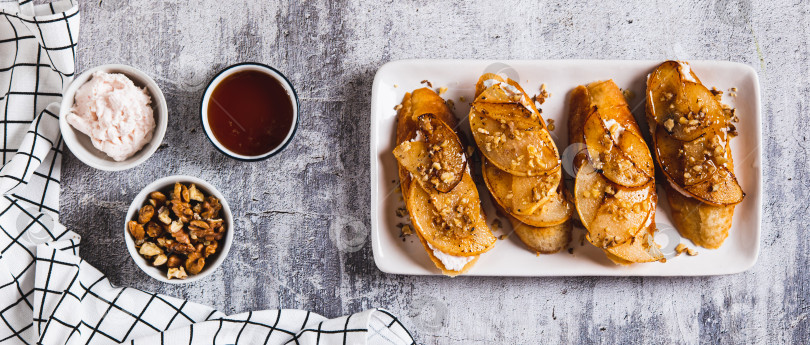 Скачать Аппетитные тосты со сливочным сыром, жареной грушей и медом на тарелке посмотреть веб-баннер сверху фотосток Ozero