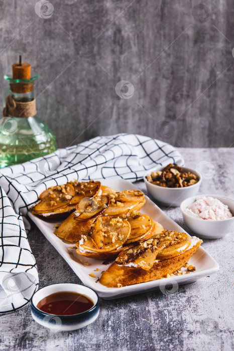 Скачать Сладкие бутерброды с рикоттой, печеной грушей, медом и орехами на тарелке на столе, вид сверху фотосток Ozero