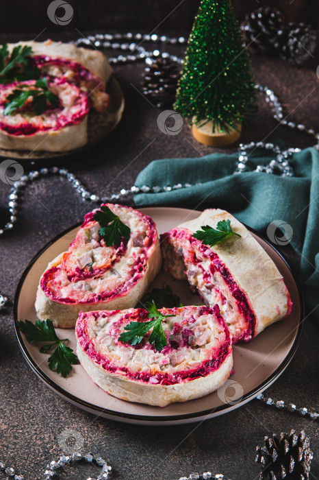 Скачать Пикантные рулетики с сельдью под шубой, салат на тарелке, на столе, вид сверху фотосток Ozero