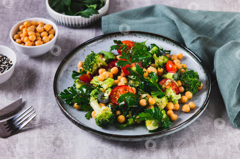 Скачать Подача на стол в тарелке со смесью из нута, помидоров, брокколи и петрушки фотосток Ozero