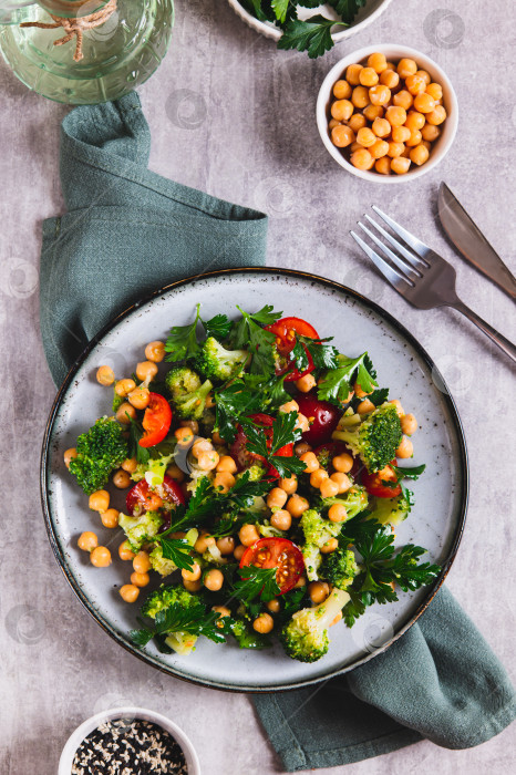 Скачать Смесь из нута, помидоров, брокколи и петрушки на тарелке, установленной на столе вертикально фотосток Ozero