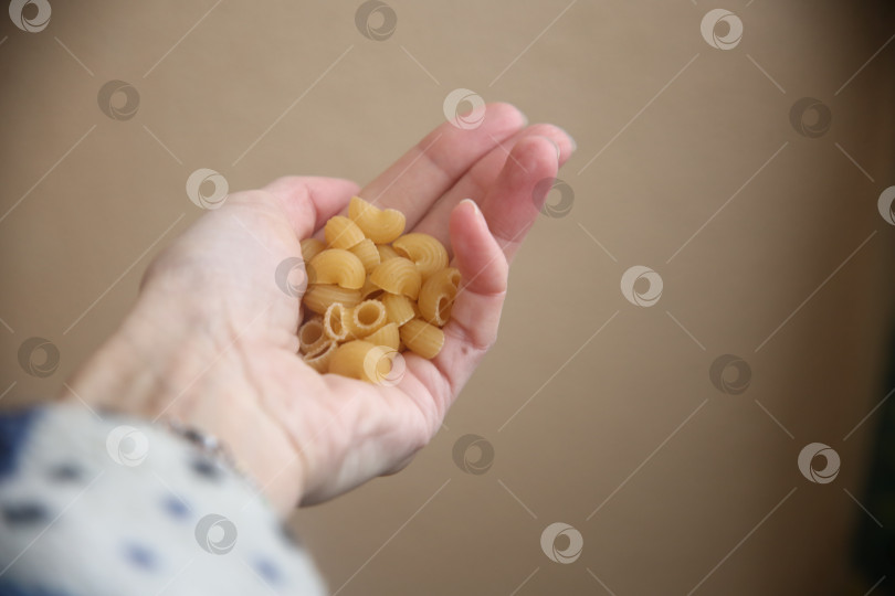 Скачать Макароны в человеческой руке фотосток Ozero