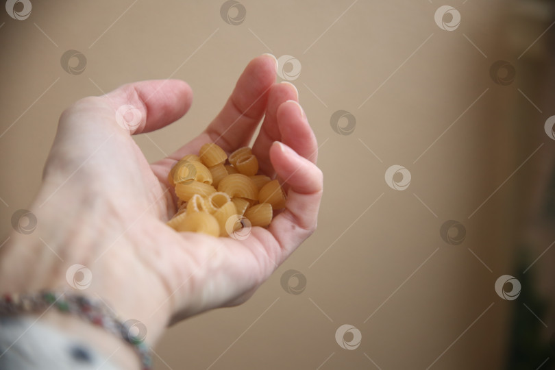 Скачать Макароны в женской руке фотосток Ozero