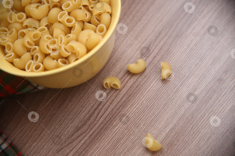 Скачать Макароны рожки на деревянном столе фотосток Ozero