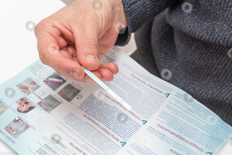 Скачать Бар, Черногория, 8 января 2026 года, Мужчина проводит портативный тест на бактерии стрептококка фотосток Ozero