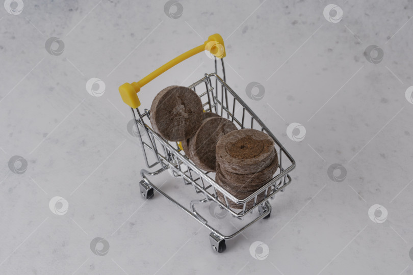 Скачать Торфяные гранулы для посева семян в корзине для покупок. Место для копирования фотосток Ozero