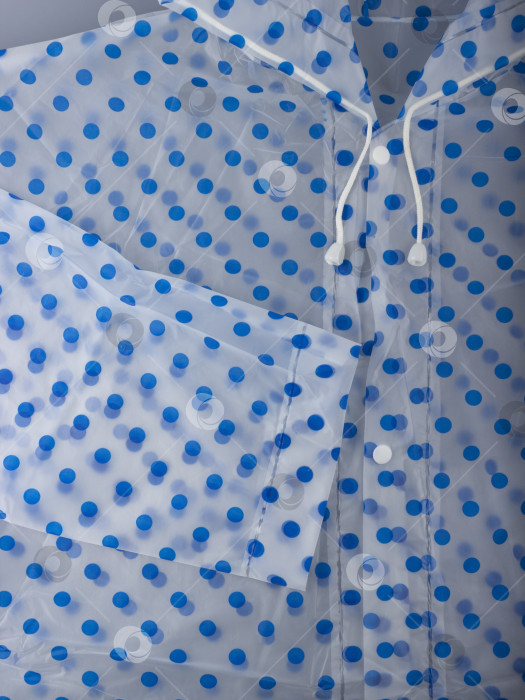 Скачать Белые завязки, пуговицы и рукава прозрачного синего плаща в горошек крупным планом фотосток Ozero