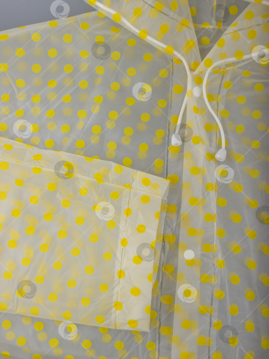 Скачать Белые завязки, пуговицы и рукава прозрачного плаща в лимонно-желтый горошек крупным планом фотосток Ozero