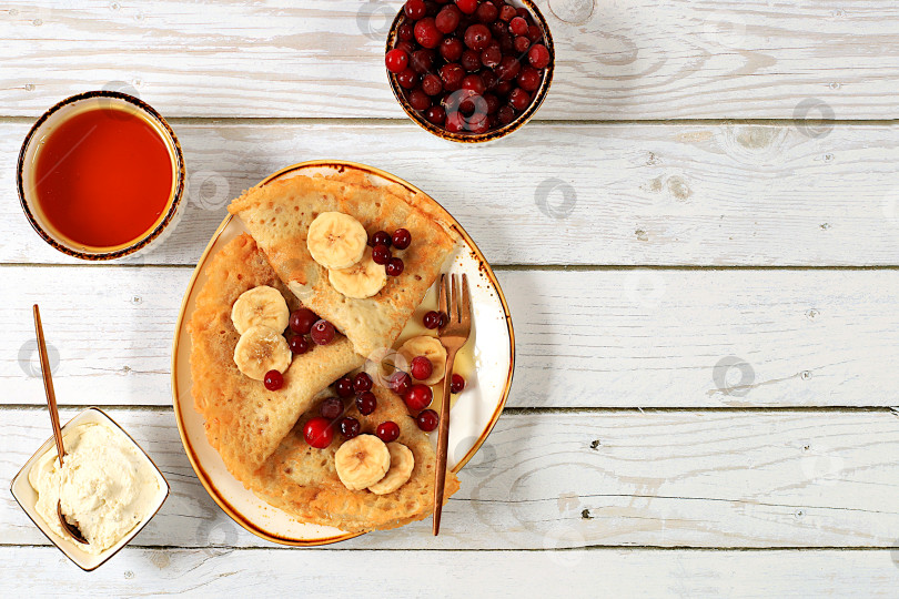 Скачать Вкусные русские блинчики с вареньем, мягким творогом, бананами, клюквой и медом на мраморном столе. Полезный завтрак из натуральных ингредиентов, концепция Масленицы, натуральные продукты фотосток Ozero