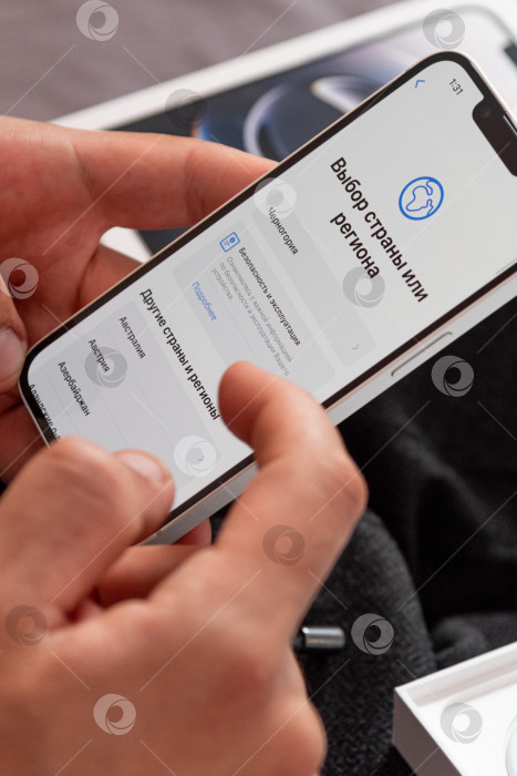 Скачать Бар, Черногория, 2 ноября 2025 года, Мужчина настраивает новый iPhone, первый запускаемый смартфон фотосток Ozero