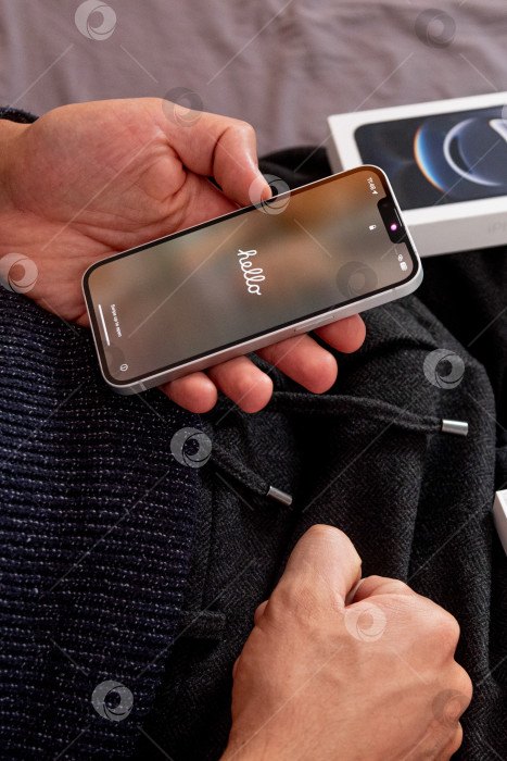 Скачать Бар, Черногория, 2 ноября 2025 года, Мужчина настраивает новый iPhone, первый запускаемый смартфон фотосток Ozero