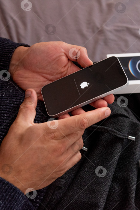 Скачать Бар, Черногория, 2 ноября 2025 года, Мужчина настраивает новый iPhone, первый запускаемый смартфон фотосток Ozero
