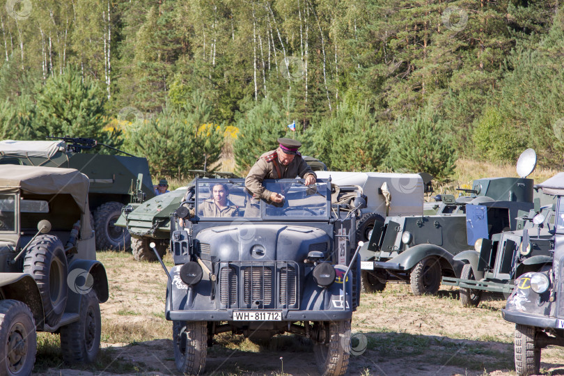 Скачать Москва, Россия, 2018-08-25, выставка военной техники, показ военной техники в действии. Военный в форме сидит в машине. фотосток Ozero