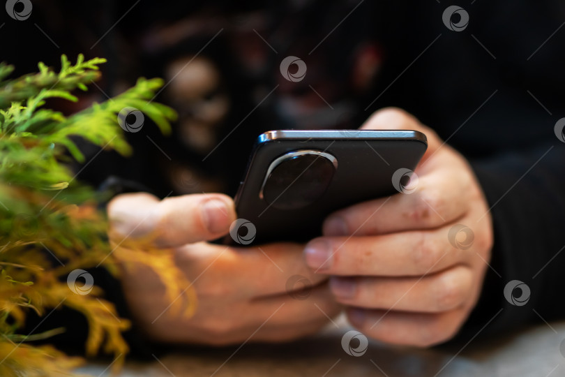 Скачать Случайный момент, когда кто-то просматривает сообщения за столиком уютного кафе фотосток Ozero