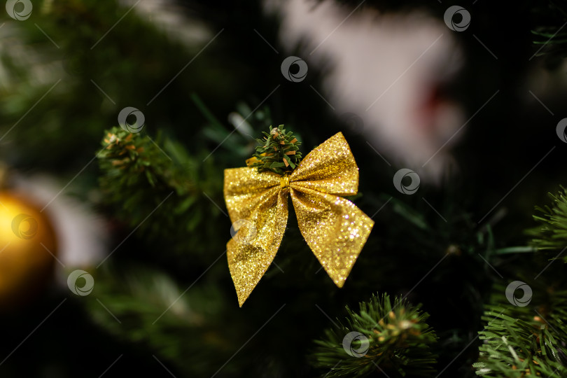 Скачать Праздничное оформление праздника, мерцающая золотая лента украшает пышную вечнозеленую ветку с огоньками фотосток Ozero