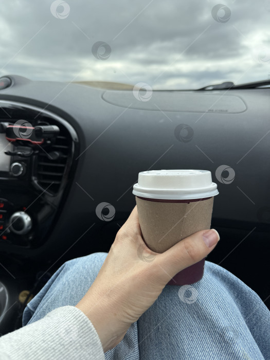 Скачать Человек с кофейной чашкой в руках в автомобиле, из окна которого открывается вид на небо фотосток Ozero