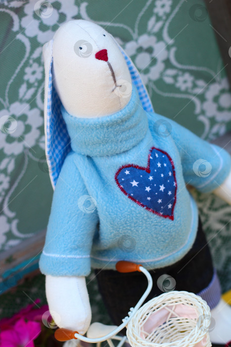 Скачать Плюшевый кролик ручной работы: Уютный пасхальный декор и креативная идея подарка с игривыми цветочными акцентами фотосток Ozero