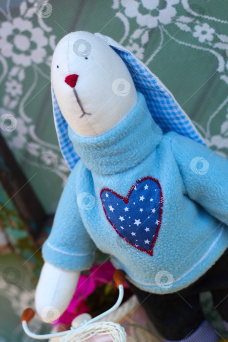 Скачать Плюшевый кролик ручной работы: Уютный пасхальный декор и креативная идея подарка с игривыми цветочными акцентами фотосток Ozero