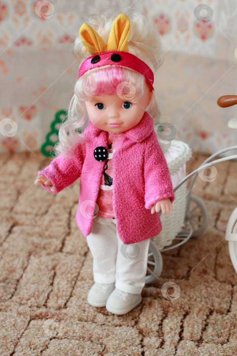Скачать Стильная кукла в розовом халате на прогулке: Миниатюрная мода сочетается с детскими играми фотосток Ozero