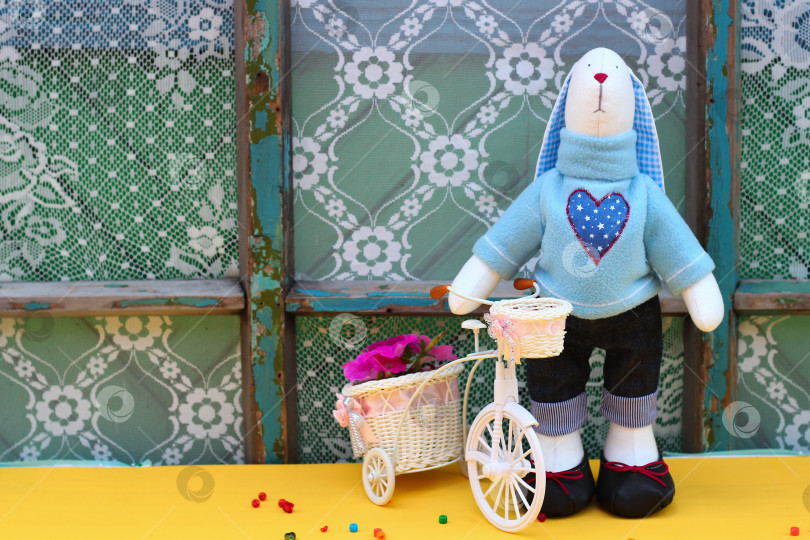 Скачать Плюшевый кролик ручной работы: Уютный пасхальный декор и креативная идея подарка с игривыми цветочными акцентами фотосток Ozero