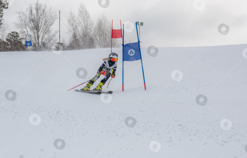 Скачать Россия, Красноярск 25 февраля 2025г. Девочка лыжница, спускается на лыжах по снежному склону. фотосток Ozero