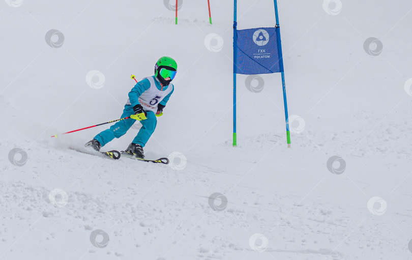 Скачать Россия, Красноярск 25 февраля 2025г. Мальчик лыжник, спускается на лыжах по снежному склону. фотосток Ozero