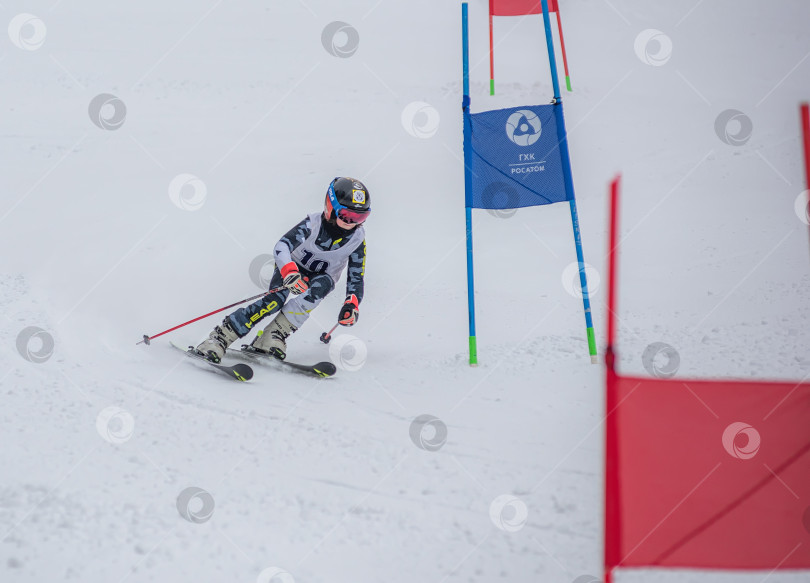 Скачать Россия, Красноярск 25 февраля 2025г. Мальчик лыжник, спускается на лыжах по снежному склону. фотосток Ozero