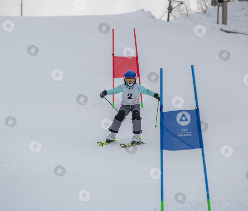 Скачать Россия, Красноярск 25 февраля 2025г. Мальчик лыжник, спускается на лыжах по снежному склону. фотосток Ozero