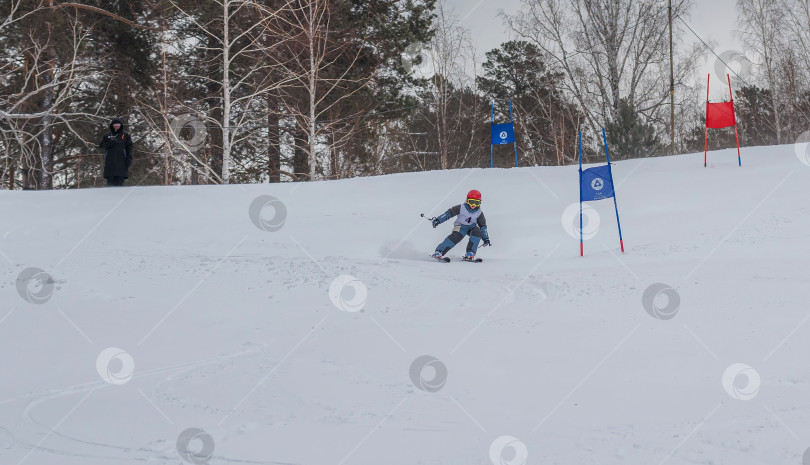 Скачать Россия, Красноярск 25 февраля 2025г. Мальчик лыжник, спускается на лыжах по снежному склону. фотосток Ozero