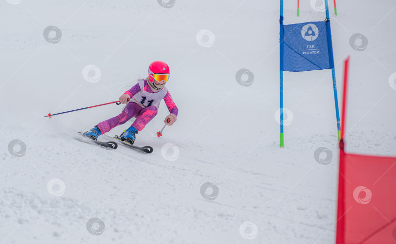 Скачать Россия, Красноярск 25 февраля 2025г. Девочка лыжница, спускается на лыжах по снежному склону. фотосток Ozero