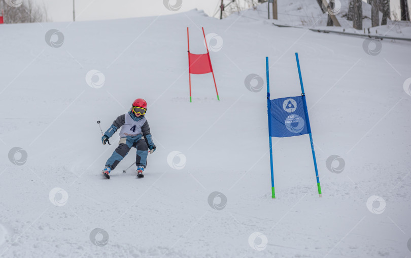 Скачать Россия, Красноярск 25 февраля 2025г. Мальчик лыжник, спускается на лыжах по снежному склону. фотосток Ozero