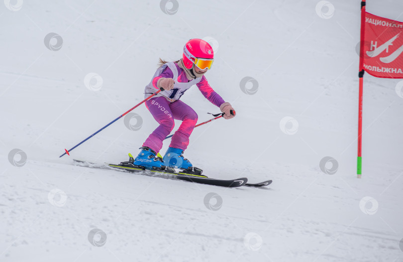 Скачать Россия, Красноярск 25 февраля 2025г. Девочка лыжница, спускается на лыжах по снежному склону. фотосток Ozero