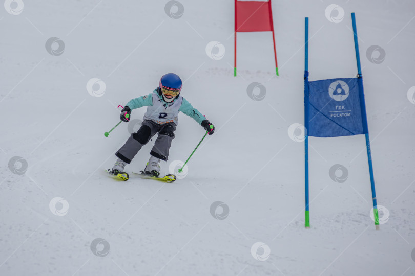 Скачать Россия, Красноярск 25 февраля 2025г. Мальчик лыжник, спускается на лыжах по снежному склону. фотосток Ozero