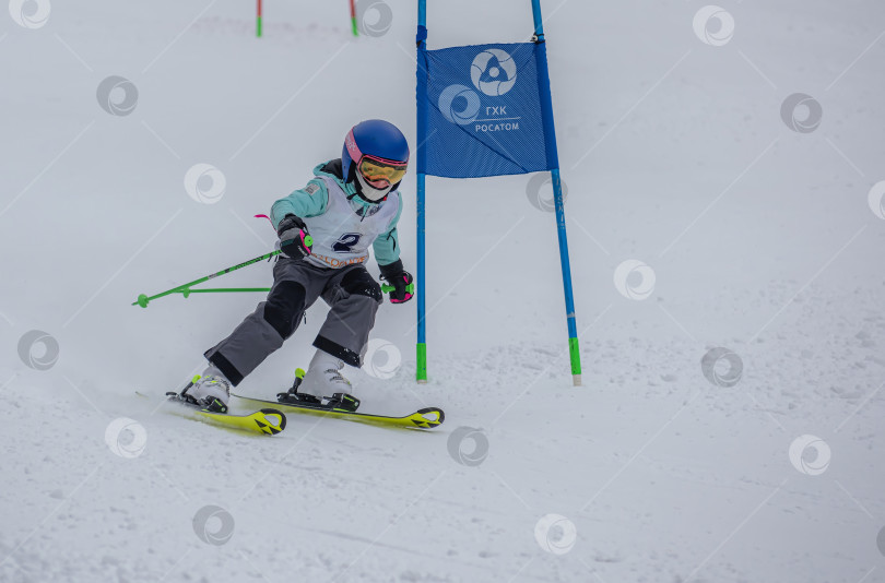 Скачать Россия, Красноярск 25 февраля 2025г. Мальчик лыжник, спускается на лыжах по снежному склону. фотосток Ozero