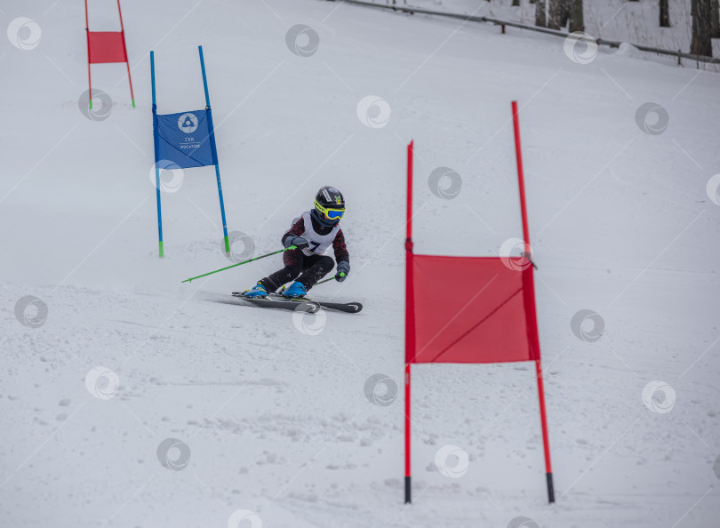 Скачать Россия, Красноярск 25 февраля 2025г. Мальчик лыжник, спускается на лыжах по снежному склону. фотосток Ozero
