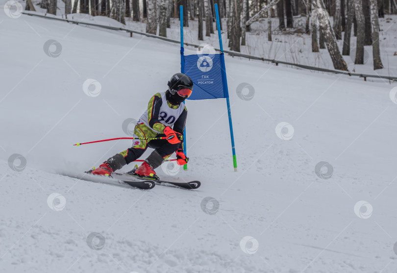 Скачать Россия, Красноярск 25 февраля 2025г. Мальчик лыжник, спускается на лыжах по снежному склону. фотосток Ozero