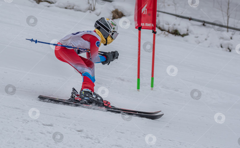 Скачать Россия, Красноярск 25 февраля 2025г. Мальчик лыжник, спускается на лыжах по снежному склону. фотосток Ozero