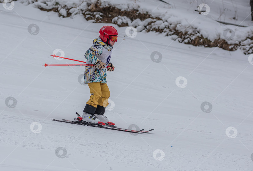 Скачать Россия, Красноярск 25 февраля 2025г. Мальчик лыжник, спускается на лыжах по снежному склону. фотосток Ozero