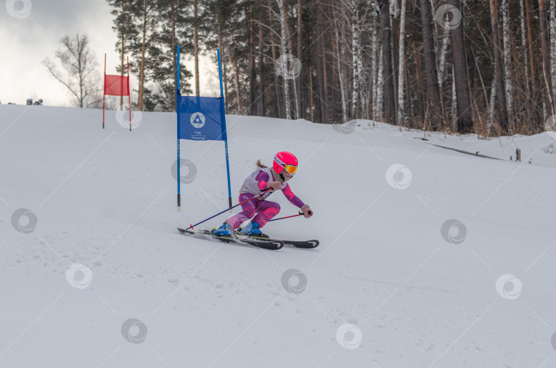 Скачать Россия, Красноярск 25 февраля 2025г. Девочка лыжница, спускается на лыжах по снежному склону. фотосток Ozero