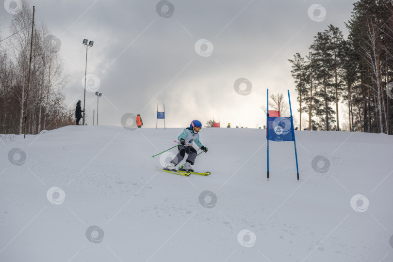 Скачать Россия, Красноярск 25 февраля 2025г. Мальчик лыжник, спускается на лыжах по снежному склону. фотосток Ozero