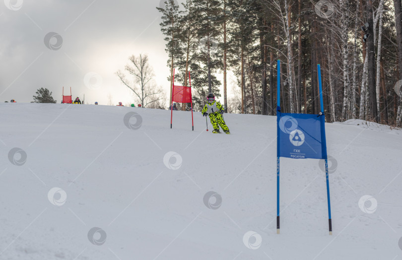 Скачать Россия, Красноярск 25 февраля 2025г. Мальчик лыжник, спускается на лыжах по снежному склону. фотосток Ozero