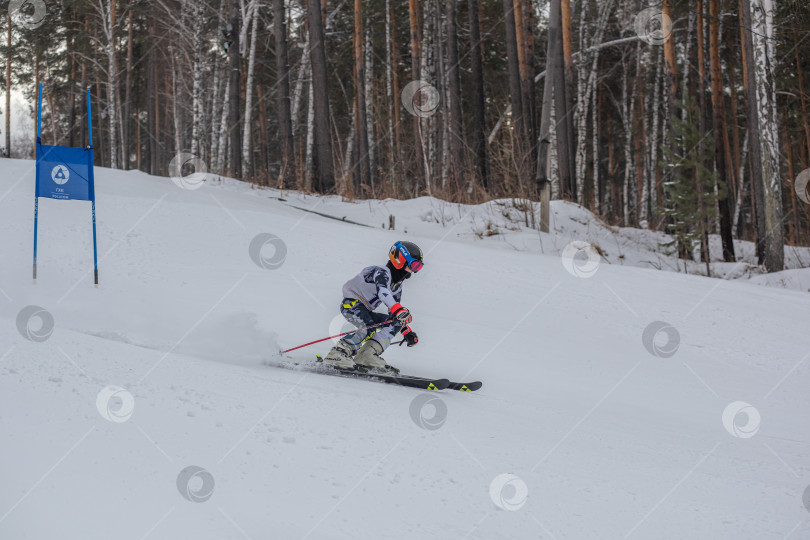Скачать Россия, Красноярск 25 февраля 2025г. Мальчик лыжник, спускается на лыжах по снежному склону. фотосток Ozero